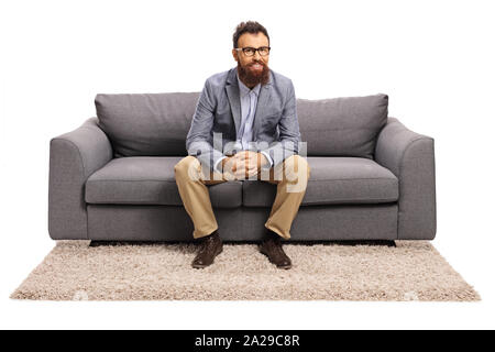 Kerl mit Brille sitzt auf einem Sofa grau auf weißem Hintergrund Bärtigen Stockfoto