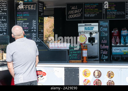 Ein älterer Mann kauft ein Eis von einem Meer Imbiss Kiosk oder Eis Verkäufer Stockfoto