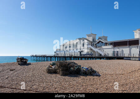 Bognor Regis Pier mit Fischernetzen und Hummer Hülsen im Vordergrund auf dem Kiesstrand Stockfoto