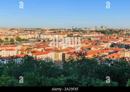 Panoramablick über die Dächer und historischen Gebäuden von Prag die Hauptstadt der Tschechischen Republik an einem sonnigen Tag mit Bäumen und Sträuchern im Vordergrund Stockfoto