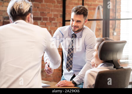 Männer die Hände schütteln, während im Team arbeiten. Business Vertrag oder Vereinbarung unterzeichnen Konzept Stockfoto