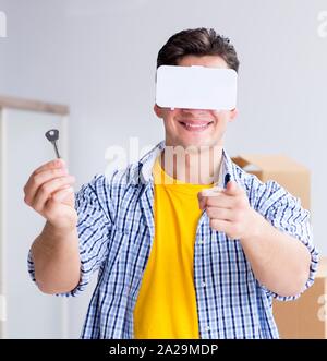 Der junge Mann, der VR-Brille Umzug in neue Wohnung Stockfoto