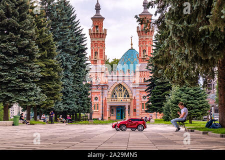 Wladikawkas, Russland - 07 18 2019 - Junge Unternehmer mit ein paar Kinder Elektroautos warten auf einen Client vor sunnitischen Moschee Mukhtarov Stockfoto