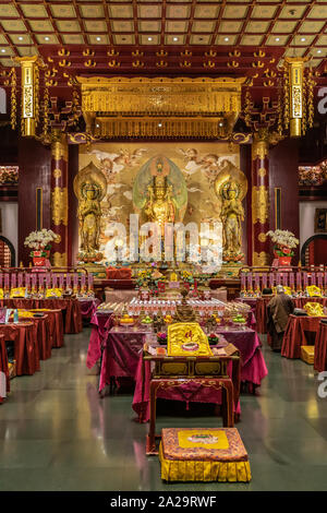 Singapur - März 22, 2019: Buddha Zahns Tempel in Chinatown. Der Gebetsraum mit sitzender Buddha Maitreya flankiert von zwei Bodhisattvas. Lose Stockfoto