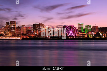 Skyline von Montreal leuchtet in der Dämmerung in St. Lawrence River, Quebec, Kanada wider Stockfoto