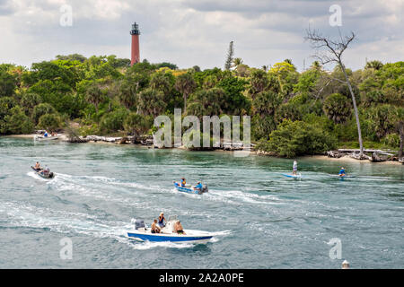 Paddel Boarder und Boote Reisen entlang der Indian River vorbei an der Jupiter Inlet Leuchtturm an der South Beach Brücke in Jupiter, Florida. Stockfoto