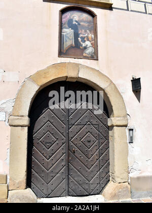 Eine schwere beschlagene Tür mit einem Gemälde oben im Innenhof von Schloss Wawel montiert Stockfoto