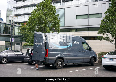 Portland, Oregon, USA - 13.September 2019: Ein Amazon Arbeitnehmer gesehen Entladen eines Amazon Prime Marke van am Straßenrand in der Innenstadt von Portland. Stockfoto