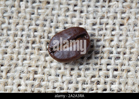 Nahaufnahme von kaffeebohne über rustikale Abdeckung Hintergrund Stockfoto