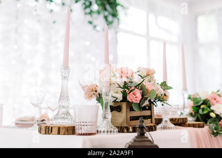 Rosa Kerzen in hohen Glas Kerzen und Blumen in einem hölzernen Kästchen Stockfoto