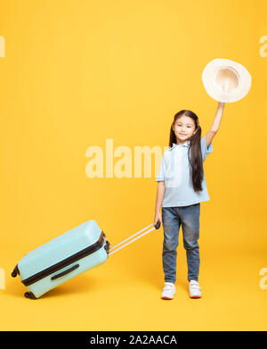 Glückliche kleine Mädchen mit Koffer in den Urlaub Stockfoto