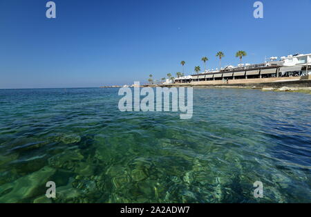 Wunderschöner Panoramablick auf die malerische Landschaft mit Meer, blauer Himmel und die Promenade mit hohen Palmen in Paphos / Paphos Zypern. Stockfoto