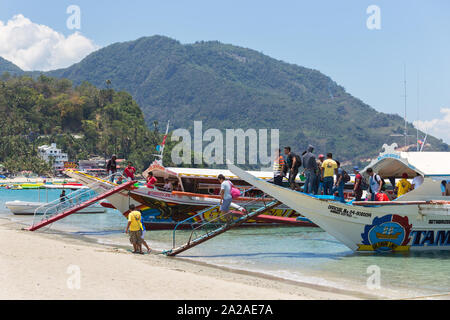 Puerto Galera, Sabang, Philippinen - April 4, 2017: Fahrgäste Touristen auf Booten in weißen Strand. Stockfoto