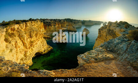 Faro, Portugal - 18. September 2019: Blaue Stunde Sonnenaufgang und entlang der Küste der Algarve in Richtung Faro von den Klippen oberhalb von Praia da Marinha, Portugal Stockfoto