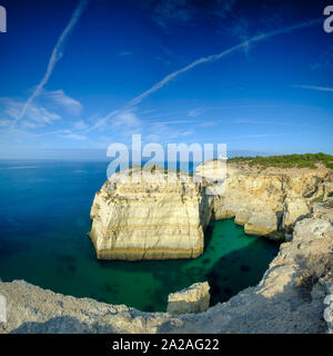 Faro, Portugal - 18. September 2019: Blaue Stunde Sonnenaufgang und entlang der Küste der Algarve in Richtung Faro von den Klippen oberhalb von Praia da Marinha, Portugal Stockfoto