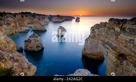 Faro, Portugal - 18. September 2019: Blaue Stunde Sonnenaufgang und entlang der Küste der Algarve in Richtung Faro von den Klippen oberhalb von Praia da Marinha, Portugal Stockfoto