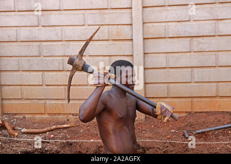 Bauarbeiter mit Pick-axe graben ein Loch für einen kleinen Swimmingpool, Moreleta Park, Pretoria, Gauteng, Südafrika. Stockfoto