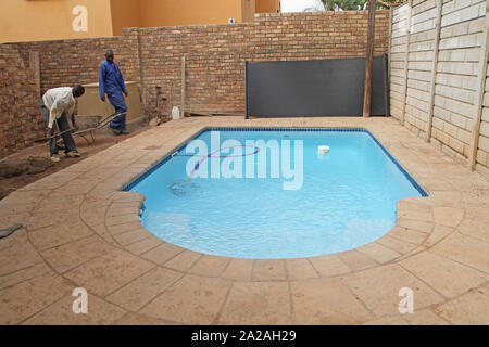 Bauarbeiter in der Nähe von Schwimmbad und Pumpe neben Baustelle, Moreleta Park, Pretoria, Gauteng Provinz, Südafrika. Stockfoto