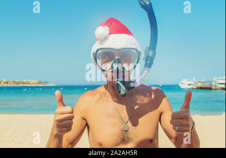 Mann in einem Santa hat in einer Maske und Flossen auf dem Meer. Selektive konzentrieren. Stockfoto