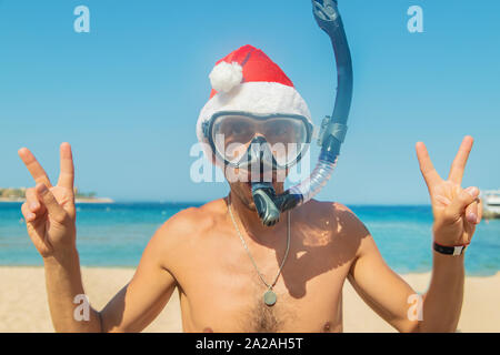 Mann in einem Santa hat in einer Maske und Flossen auf dem Meer. Selektive konzentrieren. Stockfoto