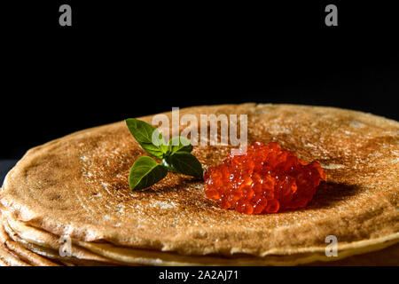 Stapel Pfannkuchen mit roter Kaviar auf schwarzem Hintergrund, in der Nähe Stockfoto