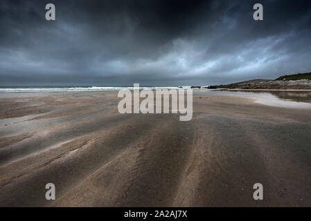 Dunkle dramatische Kühle herbstliche Wetter über eine einsame Fistral Beach in Newquay in Cornwall. Stockfoto