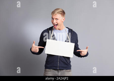 Freudiger mensch Zeigefinger auf leerer Namensschild. Stockfoto