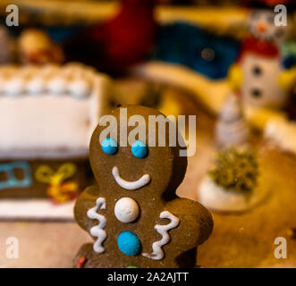 Weihnachtsschmuck gegen verschwommenen Hintergrund. Happy Gingerbread Man. Stockfoto