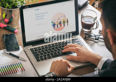 Athen, Griechenland. September 18, 2019. Junger Mann bei der Arbeit mit einem Laptop, LinkedIn Seite auf dem Bildschirm des Computers, Arbeitsbereich Stockfoto