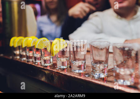 Barkeeper gießen stark alkoholisches Getränk in kleinen Gläsern auf Bar, Schüsse. Stockfoto