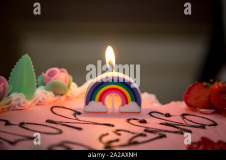 Regenbogen Kerzen auf den ersten Geburtstag Kuchen, Mädchen Stockfoto