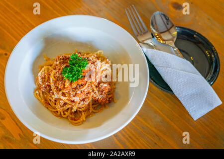 Teller mit leckeren Spaghetti mit geriebenem Käse und Petersilie dekoriert Stockfoto