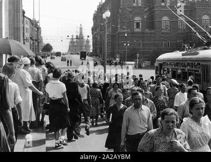 Passanten auf der Straße in Moskau. Im Hintergrund die Kathedrale von Vasily der Seligen (gemeinhin als die Basilius-kathedrale bekannt) auf dem Roten Platz. Stockfoto