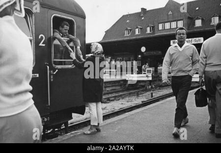 Eine Dame nimmt Abschied von einem Herrn in den Zug in den Bahnhof Westerland auf der Insel Sylt. Stockfoto