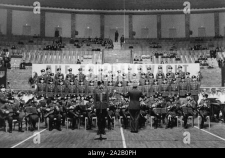 Das Bild wurde vermutlich auf einer Präsentation oder eine Generalprobe für ihre Leistung auf der "Tag der Nationalen Volksarmee" (Tag der Nationalen Volksarmee), die Ehrenmitglieder und der Memorial Tag der NVA, dass ab 1957 jährlich am 01.03. statt. Das Bild zeigt die Männer Chor und das Orchester während ihrer Performance. Stockfoto