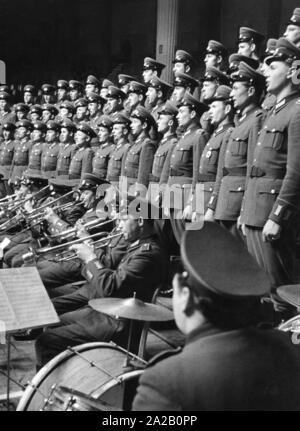 Das Bild wurde vermutlich auf einer Präsentation oder eine Generalprobe für ihre Leistung auf der "Tag der Nationalen Volksarmee" (Tag der Nationalen Volksarmee), die Ehrenmitglieder und der Memorial Tag der NVA, dass ab 1957 jährlich am 01.03. statt. Das Bild zeigt die Männer Chor und das Orchester während ihrer Performance. Stockfoto