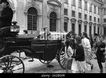 Im Juni 1959, Kim Novak besuchten das Schloss Schleißheim in München. Es war eine Art PR-Veranstaltung, an der zahlreiche Vertreter aus der Film- und Filmindustrie sowie Dutzende drücken Sie Leute eingeladen wurden. Das Bild zeigt Kim Novak, in einer Kutsche zum Schloss. Sie wird von den zahlreichen Fans und Fotografen umgeben. Stockfoto