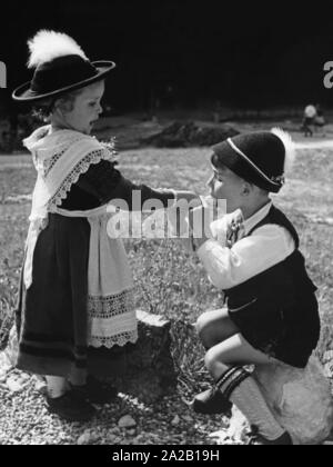 Das Mädchen lässt die junge beißen ihr Eis. Undatiertes Foto, vermutlich in den 1960er Jahren. Stockfoto