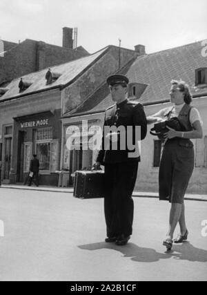 Ein sowjetischer Offizier geht mit seiner Firma über eine Straße. Das Bild wurde vermutlich im Jahre 1955 im Zuge der Unterzeichnung des Österreichischen Staatsvertrages in Baden bei Wien. Undatiertes Foto, vermutlich von 1955. Stockfoto