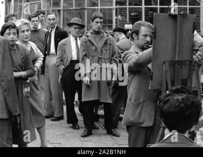 Ein street artist in Montmartre, malt er an seiner Staffelei. Mehrere Menschen beobachten ihn. (Undatiertes Foto) Stockfoto