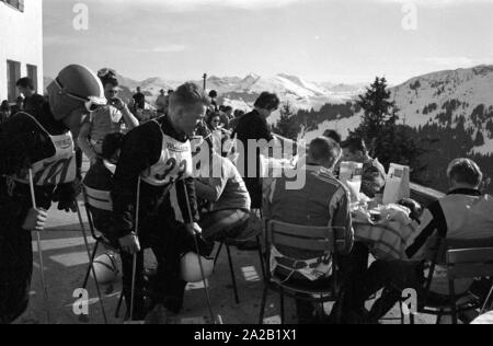 Einige Rennläufer eine Pause auf der Terrasse der Skihütte. Abgesehen von Ihnen, regelmäßige Besucher und Touristen sitzen dort auch für einige Pisten waren für die Öffentlichkeit zugänglich. Der Hahnenkamm Rennen wurde am Hahnenkamm in Kitzbühel seit 1931. Stockfoto