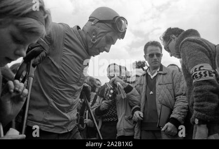 Foto von Ski Racer Anton Engelbert "Toni" Sailer umgeben von Drücker. Nach seiner Zeit als Athlet, Toni Sailer machte eine Karriere als Schauspieler, Sänger und Trainer des OSV. Das Foto wurde am Hahnenkamm Rennen 1962. Der Hahnenkamm Rennen hatte seit 1931 am Hahnenkamm in Kitzbühel. Stockfoto