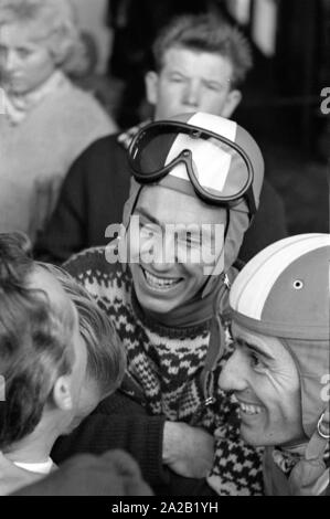 Skifahrer Toni Sailer ist im Gespräch mit einem anderen Teilnehmer des Hahnenkamm Rennen und einige Zuschauer. Das Foto wurde vermutlich an der Seilbahnstation in Kitzbühel genommen, von wo aus die Sportler auf der Piste fuhr mit dem Auto von der Seilbahn. Der Hahnenkamm Rennen wurde am Hahnenkamm in Kitzbühel seit 1931. Stockfoto