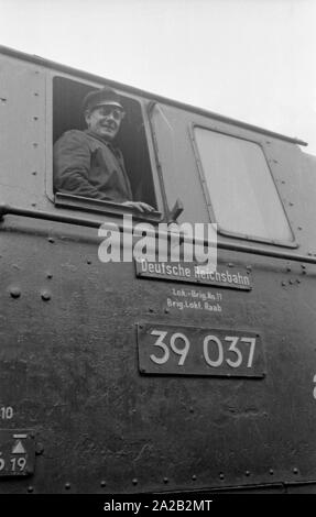 Die interzonal Zug auf der Strecke Leipzig-Gutenfuerst - Hof-Munich nach seiner Ankunft an der Grenze entfernt. Dieser Zug wurde für seine "Deutschen" Speisewagen, die beliebt wegen der 1 wurde bekannt: 1 Wechselkurs, besonders unter Ostdeutschen Reisende. Hier, im Osten deutsche Lokführer, der aussieht aus seiner Lokomotive der Deutschen Reichsbahn (deutschen Staatsbahnen). Stockfoto