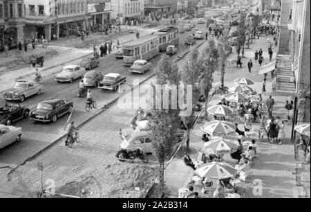 Blick auf die Leopoldstraße in München. Das Bild zeigt den Verkehr auf der Leopoldstraße, auf der unteren, rechten, einer der vielen Straßencafés. Stockfoto