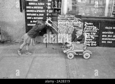 Blick auf die Leopoldstraße in München. Das Bild zeigt zwei warten Kinder vor einer Metzgerei. Stockfoto