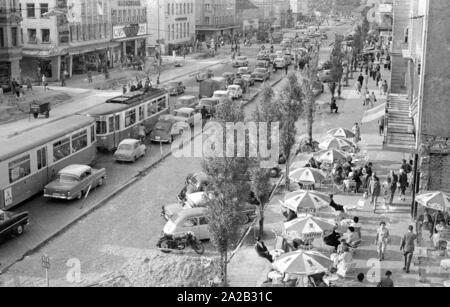 Blick auf die Leopoldstraße in München. Das Bild zeigt den Verkehr auf der Leopoldstraße, auf der unteren, rechten, einer der vielen Straßencafés. Stockfoto