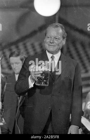 Das Bild zeigt den damaligen Bundeskanzler Willy Brandt eine Holding Becher in seiner Hand am Rednerpult der Fischer-Vroni Festzelt. Stockfoto