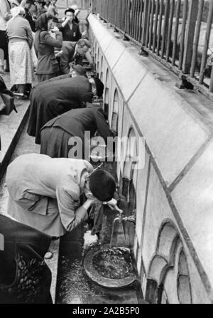 Im heiligen Bezirk der Wallfahrtsort Lourdes, Gläubige trinken aus dem Wasser, das Sie glauben zu haben, wundersame Heilung (Undatiertes Foto). Stockfoto