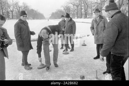 Dan Blocker, lehnte sich in der Mitte, wer spielt die Rolle der Hoss Cartwright in der Fernsehserie Bonanza, Eisstockschießen auf dem Nymphenburger Kanal in 1971. Stockfoto